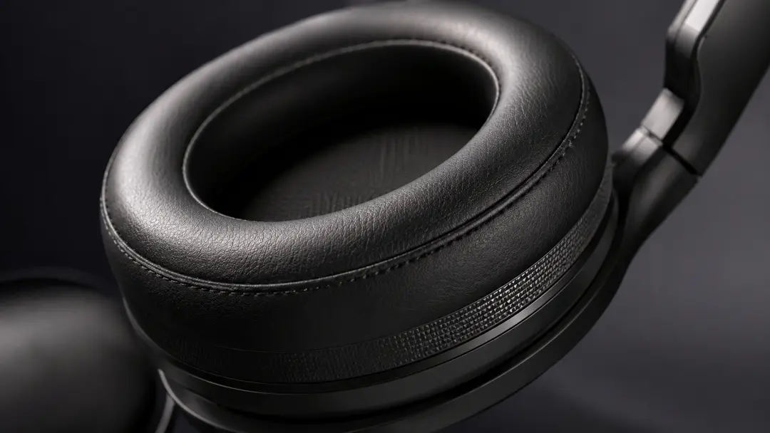 Cận cảnh đệm tai mềm của headset gaming, chất liệu foam/da PU, ánh sáng studio sạch, nhấn vào độ êm và thoải mái khi đeo lâu